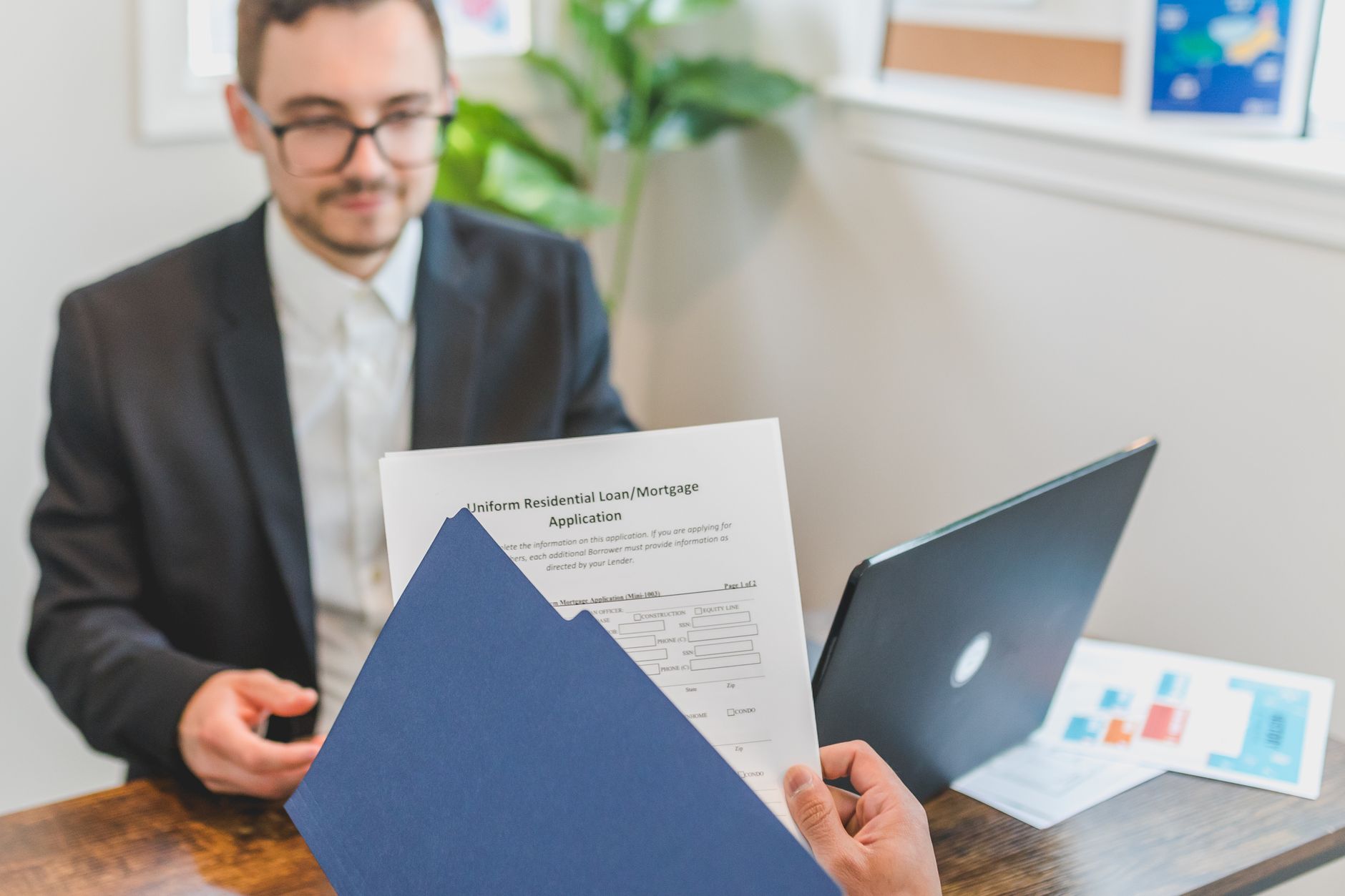 Doradca finansowy omawia z klientem wniosek o pożyczkę przy biurku