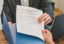 Pożyczka online bez zaświadczeń – jak bezpiecznie wziąć szybką gotówkę przez internet Przekazanie wniosku kredytowego między dłońmi w biurze