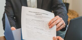 Przekazanie wniosku kredytowego między dłońmi w biurze