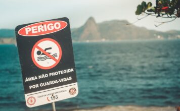 Bezpieczeństwo w Brazylii oczami turysty: sprawdzone zasady, których warto się trzymać Znak ostrzegawczy na plaży w Rio de Janeiro informujący o braku ratownika