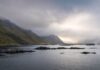 Lofoty zimą czy latem? Praktyczny przewodnik po najbardziej fotogenicznych wyspach Mglisty fiord na Lofotach z górami i chmurnym niebem w Norwegii