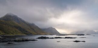 Mglisty fiord na Lofotach z górami i chmurnym niebem w Norwegii