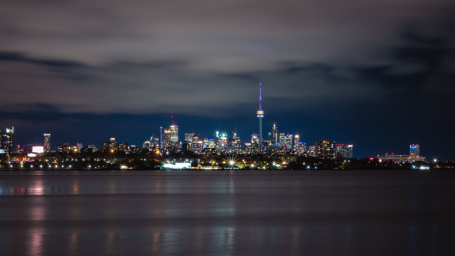 Nocna panorama Toronto z oświetloną wieżą CN odbijającą się w jeziorze