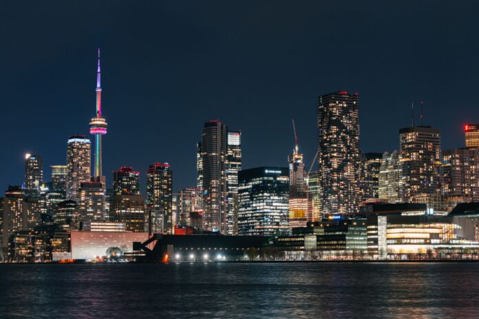 Nocna panorama Toronto z podświetloną wieżą CN odbijającą się w wodzie