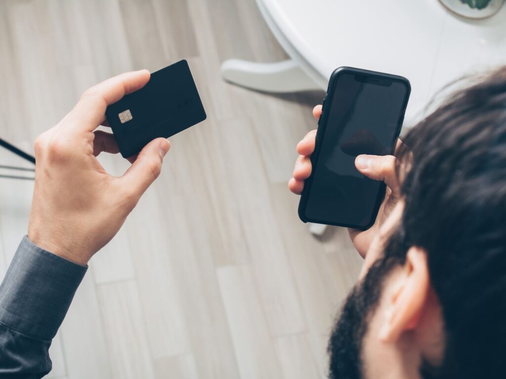 Mężczyzna płaci online smartfonem i kartą kredytową w Brazylii